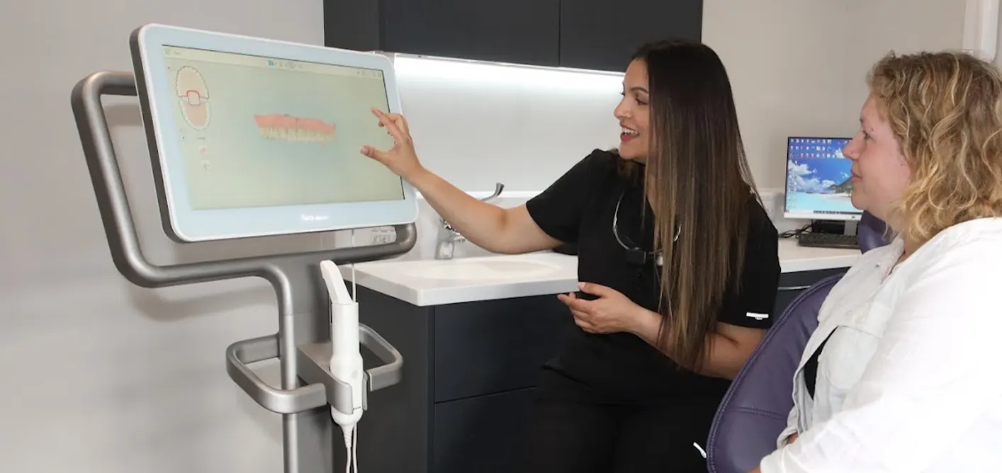 Dentist showing a patient a 3D scan of their teeth on screen